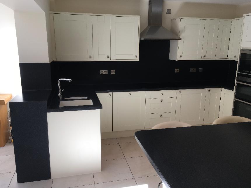 DuPont Corian deep black quartz deep colour technology island breakfast bar drop down slab waterfall end corian avante sinks instant boiling water tap coved splashback solid surface kitchen worktops